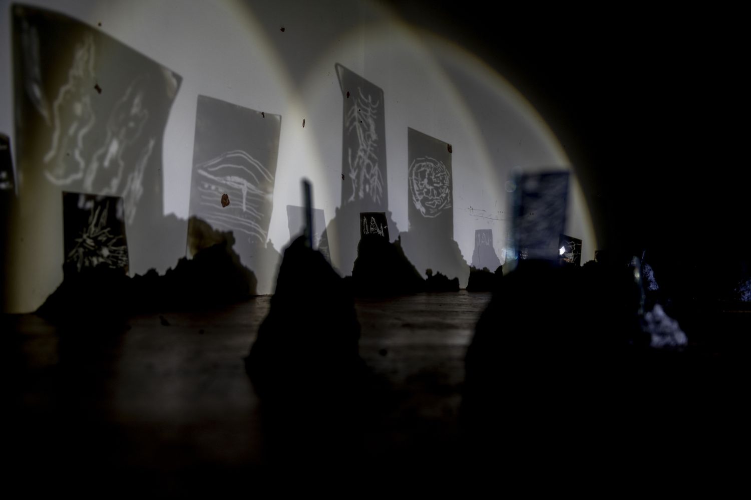 Installation by Bárbara Acevedo Strange, created for the public program of the Bosque Pehuén–Ecologies of Fire residencies, at Casa Varas, a cultural center in Temuco, La Araucanía, April 2024. A shadow play with glass and symbols inspired by fire, created in ash over fire, which later inspired the creation of “The Forest Fire as a Planetarium: A Prophetic Game.” Maya Errázuriz.